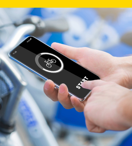 Person using bike-sharing app on phone near parked bikes.