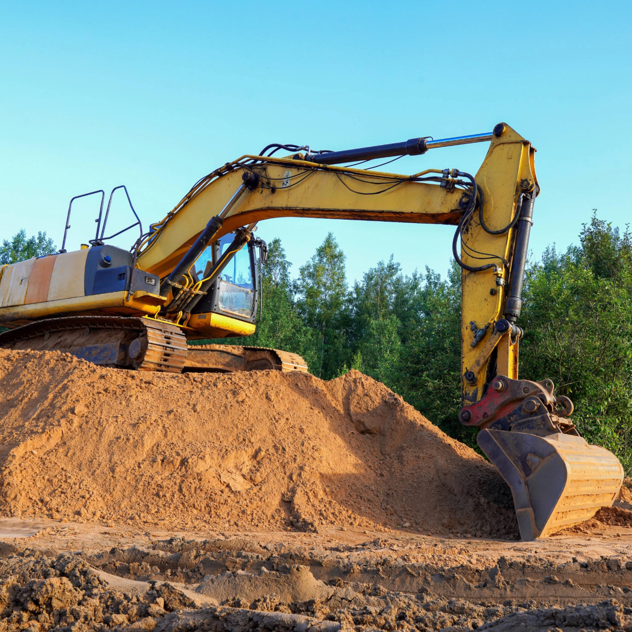 Heavy construction equipment on excavation on construction site